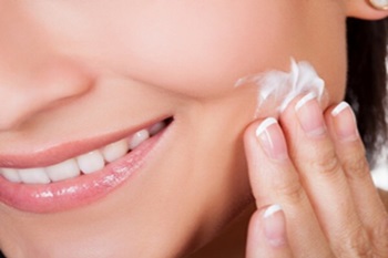 Woman Rubbing Replenishing Skin Cream into Her Face